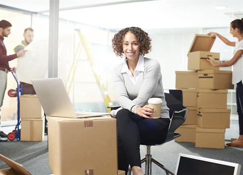 female business woman surrounded by moving boxes