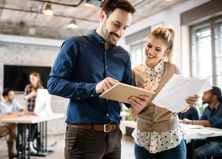 Two professionals reviewing implementation reports in an office