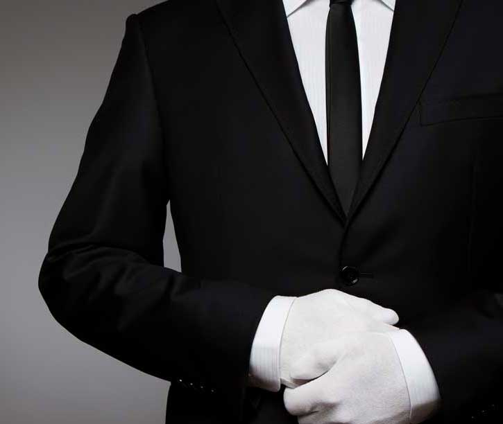 Butler wearing white gloves