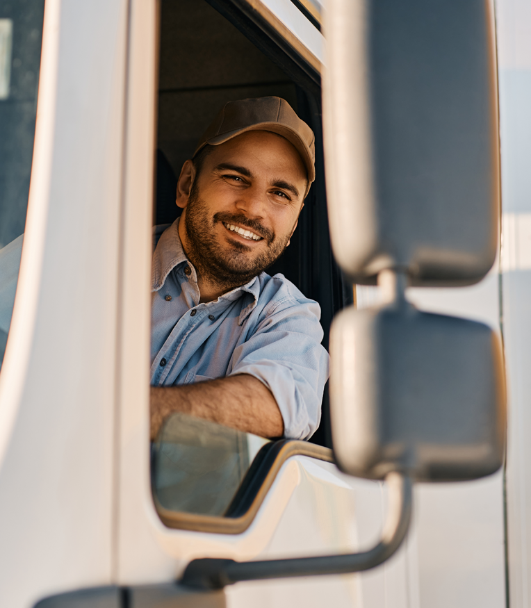 Happy truck driver looking through side window while driving