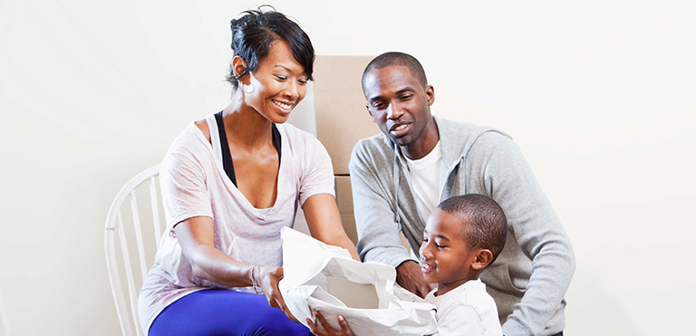 Little-boy-plays-in-box-with-his-parents